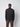 A man is seen from behind wearing a PROJEK RAW Mens Half-zip Cashmere Touch Sweater in dark gray with brown cargo pants, standing against a plain light gray background.