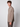 A young man with curly brown hair stands sideways, looking at the camera, wearing PROJEK RAWs Mens 24/7 Button-up Shirt and matching pants against a neutral background.