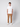A man stands facing forward against a light background, wearing a white t-shirt, PROJEK RAW Mens Bungee Relaxed Chino Pant in tan, and white sneakers.