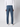 A person stands facing away from the camera, wearing PROJEK RAW Mens Bungee Relaxed Chino Pant, a white long-sleeve shirt, and white sneakers against a plain light background.