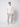 A man stands against a plain light background wearing a white textured zip-up sweater, PROJEK RAW Men’s Stretch Bungee Cargo Jogger in light gray, and white sneakers, looking directly at the camera with a neutral expression.