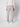 A person stands facing away, wearing a cream knit sweater, PROJEK RAW Men’s Stretch Bungee Cargo Jogger in light gray, and white sneakers against a plain light background.