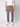 A person stands against a plain light background, wearing a white short-sleeve shirt, PROJEK RAW Men’s Stretch Bungee Cargo Jogger in taupe, and white sneakers. The individual’s head is not visible in the image.