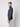 A young man with short blond hair wears a PROJEK RAW Mens Long Sleeve Turtleneck Sweater in navy blue and light beige pants, standing in profile against a plain light gray background.