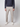 A man models the PROJEK RAW Mens Relaxed 5-Pocket Pant, styled with a navy sweater and white sneakers, standing against a plain light background. The photo is cropped at the shoulders.
