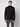 A young man stands against a plain light background, wearing a PROJEK RAW Mens Long Sleeve Turtleneck Sweater in black and gray pants. He faces forward with a neutral expression and his arms at his sides.