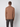 A man faces away from the camera, wearing the PROJEK RAW Mens Half-zip Cashmere Touch Sweater in brown with dark pants, set against a plain light background.