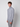 A young man with curly brown hair models the PROJEK RAW Mens Long Sleeve Turtleneck Sweater in light gray and gray plaid pants, standing against a plain white background and looking slightly to the side.