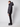 A person stands in profile against a plain background, wearing the PROJEK RAW Mens Quilted Ecofill Puffer with hood, paired with black pants and chunky black shoes.