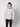 A young man with curly hair wears the PROJEK RAW Mens Quilted Ecofill Puffer with hood in light gray, featuring front buttons, pockets, and drawstrings, paired with black pants against a plain white background.
