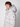 A young man with curly brown hair models the PROJEK RAW Mens Quilted Ecofill Puffer with hood in light gray, standing against a white background and looking to the side—a stylish choice for cold weather.