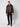 A man with short hair and a neutral expression stands against a white background wearing the PROJEK RAW Mens Vegan Leather Moto Jacket with Removable Hood, paired with a black shirt, black pants, and black shoes.