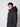 A young man with curly brown hair wears a PROJEK RAW Mens Textured Ripstop Ecofill Quilted Parka with Hood, standing against a plain light background and looking slightly to the side with a neutral expression.