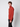 A young man with curly brown hair stands sideways, looking at the camera in a rust-colored long-sleeve quarter-zip sweater and PROJEK RAW Mens Relaxed 5-Pocket Pant against a plain light gray background.
