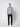 A person stands facing forward against a plain light background, wearing a light gray quarter-zip sweater, PROJEK RAW Mens 5-pocket Classic Stretch Bungee Pants, and black shoes.