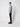 A man stands in profile against a plain white background, wearing a light gray turtleneck sweater and PROJEK RAW Mens 5-pocket Classic Stretch Bungee Pants in black, paired with black shoes.