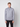 A young man with short light brown hair stands against a plain background, wearing the PROJEK RAW Mens Half-zip Cashmere Touch Sweater in light gray and black pants, looking straight at the camera with a neutral expression.