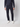 A person in PROJEK RAW Mens 5-pocket Classic Stretch Bungee Pants and white sneakers stands against a plain light background, with only their lower torso and legs visible.