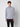 A man stands against a plain light background, wearing the PROJEK RAW Mens Long Sleeve Full Zip Mock Neck Sweater in light gray and black pants, looking directly at the camera with a neutral expression.
