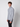 A young man with curly brown hair wears the PROJEK RAW Mens Long Sleeve Full Zip Mock Neck Sweater in light gray and black pants, standing against a plain light gray background, facing slightly to the side.