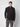 A young man with short light brown hair wears the PROJEK RAW Mens Zip Mock Neck Sweater and gray cargo pants, standing against a plain light background with one hand in his pocket.