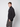 A young man with short light brown hair poses against a plain background, wearing a PROJEK RAW Mens Zip Mock Neck Sweater in a dark textured style and gray pants, standing with one hand in his pocket and looking at the camera.