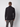A man stands with his back to the camera, wearing a black PROJEK RAW Mens Zip Mock Neck Sweater and gray cargo pants, set against a plain light gray background.