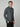 A man with short light brown hair wears the PROJEK RAW MENS 24/7 BUTTON-UP KNIT SHIRT and black pants, standing facing forward with one hand in his pocket against a light gray background.